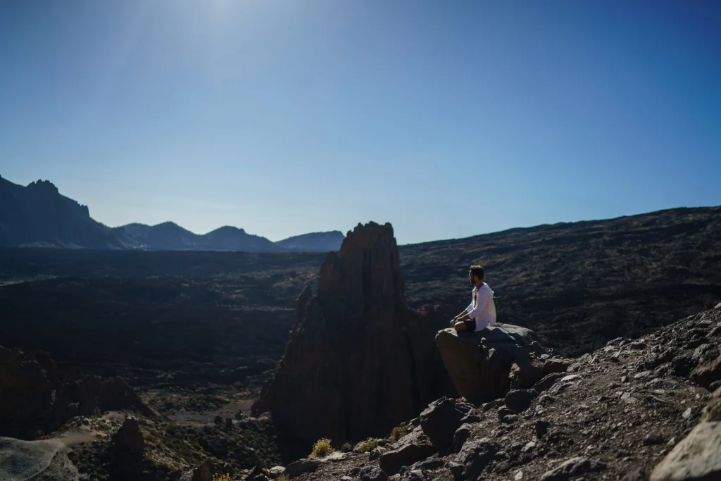 man practicing mindfulness on rock